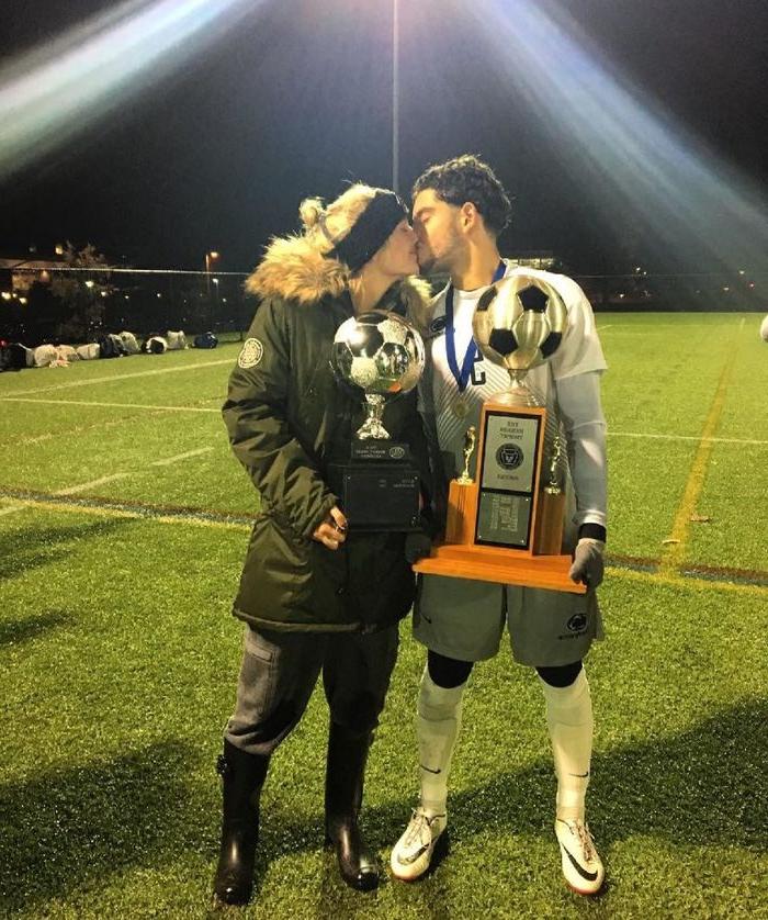 esteban and ami kissing while holding trophies